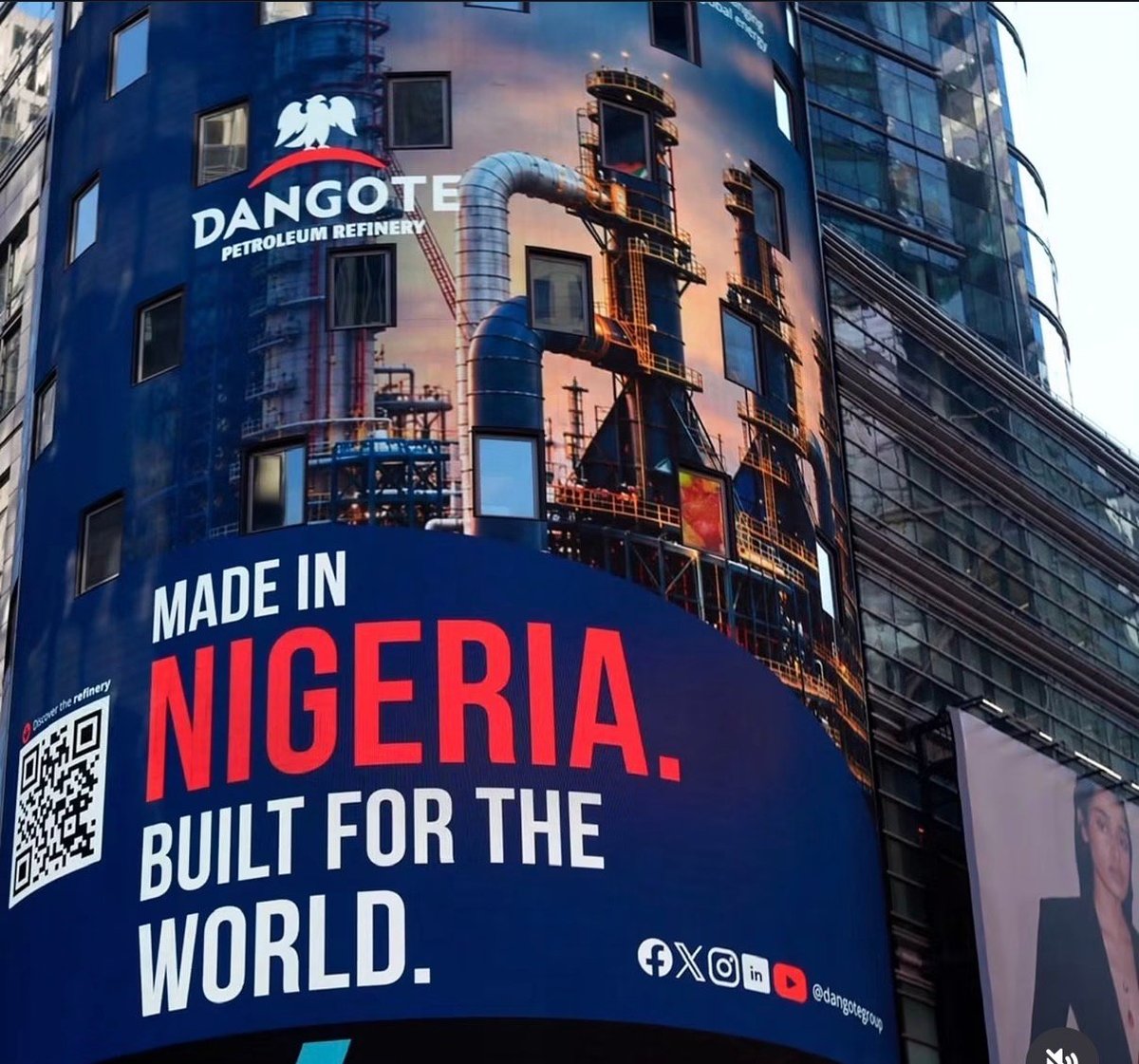 Dangote petroleum advertisement on tall building with text Made in Nigeria. Built for the World. and industrial imagery